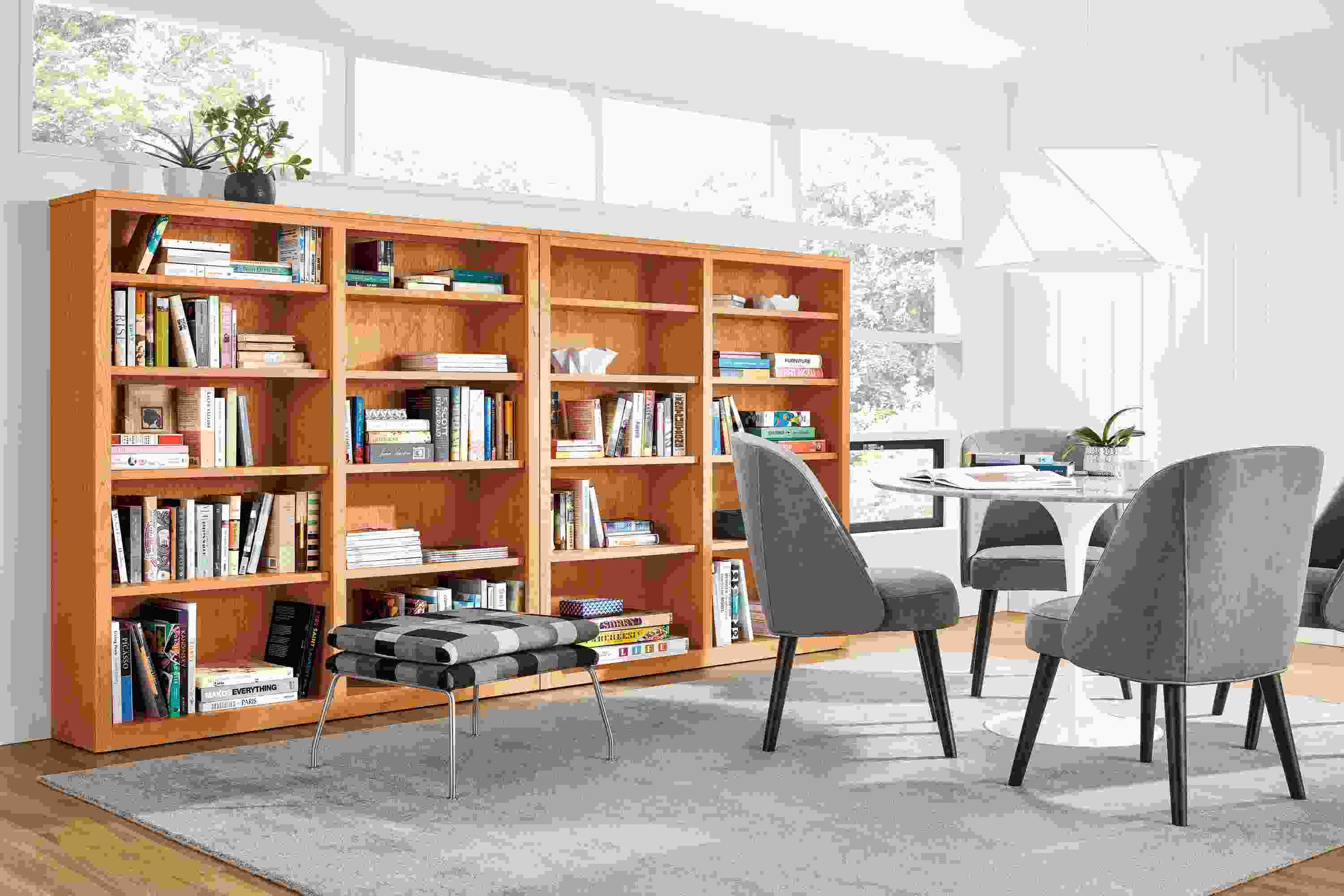 Large bright room with Woodwind bookcases in cherry and Cora chairs in Annata Grey with charcoal legs.