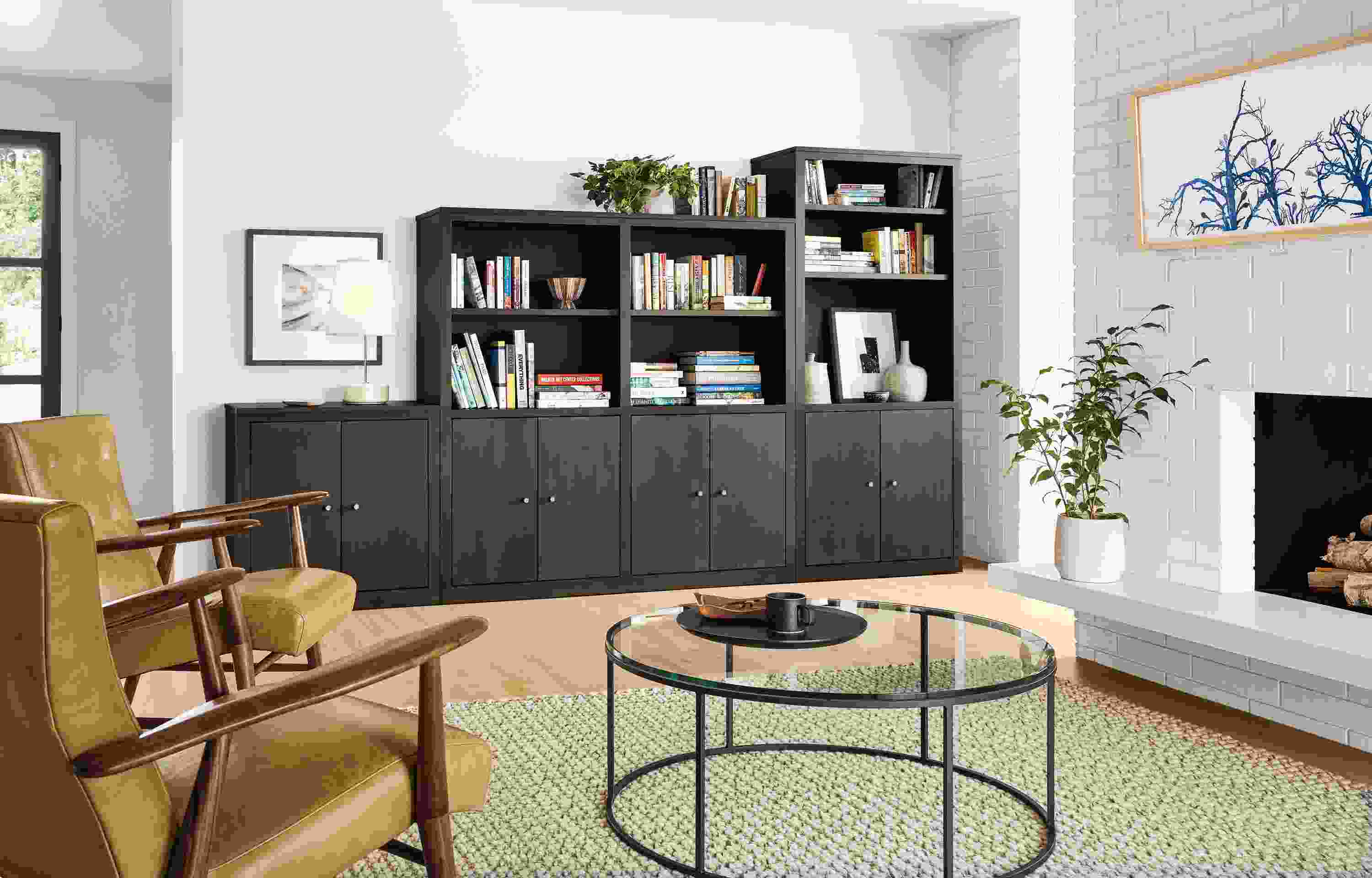 Living room with Woodwind bookcases in various heights in charcoal and Wallace rug in earth.