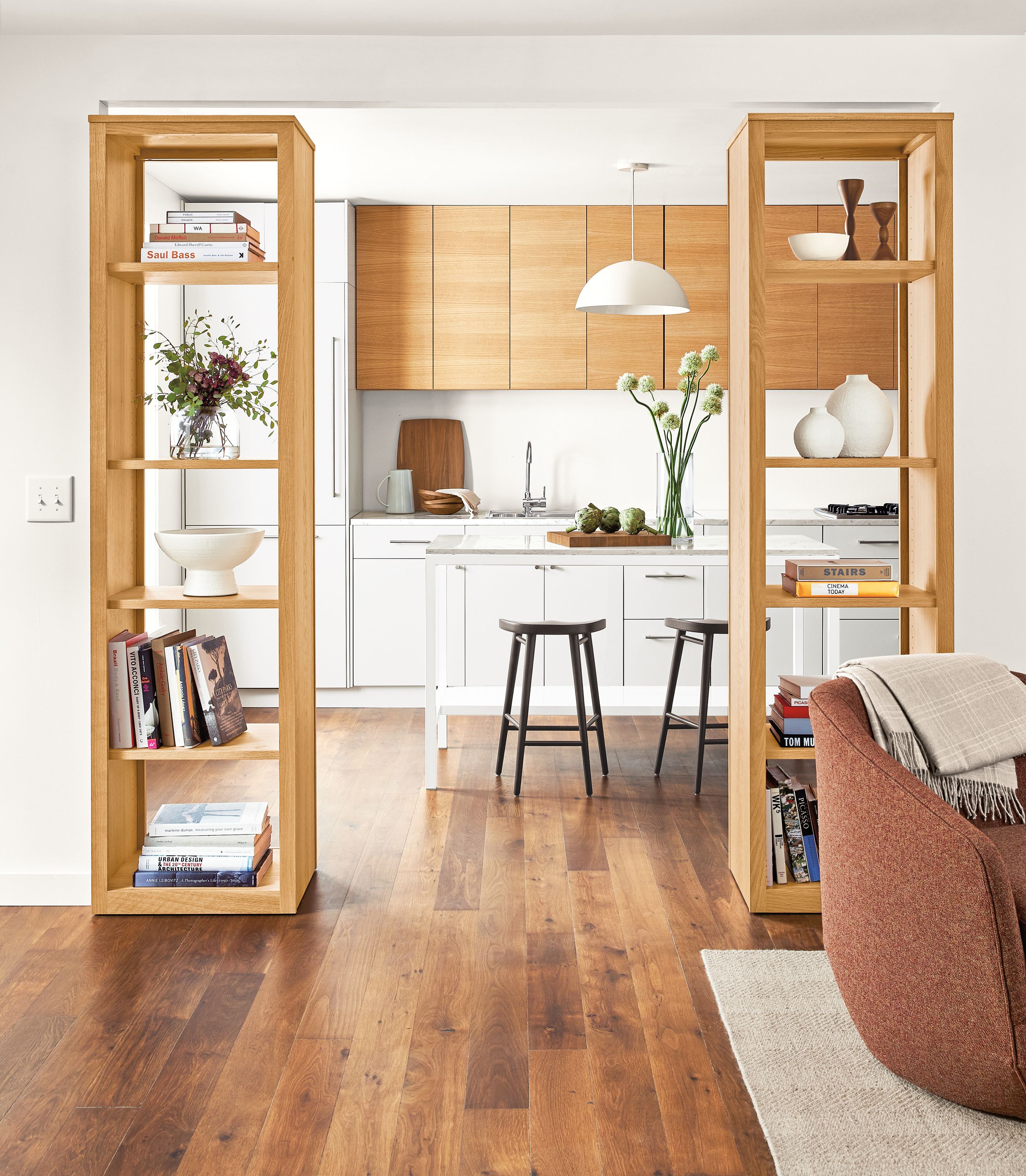 Detail of Woodwind open back bookcases in white oak between kitchen and living room.