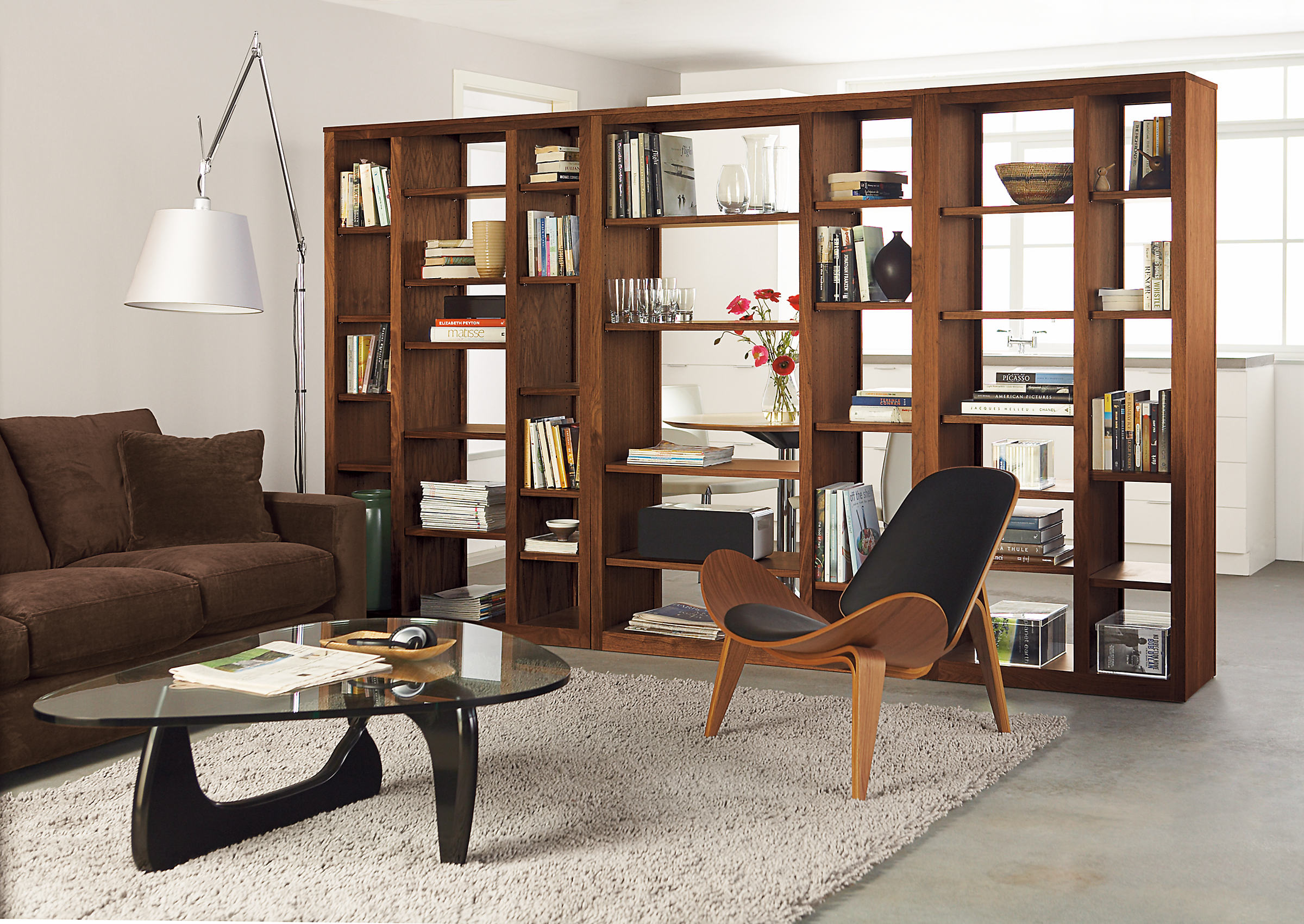 Living room with three woodwind open bookcases in walnut in various sizes.