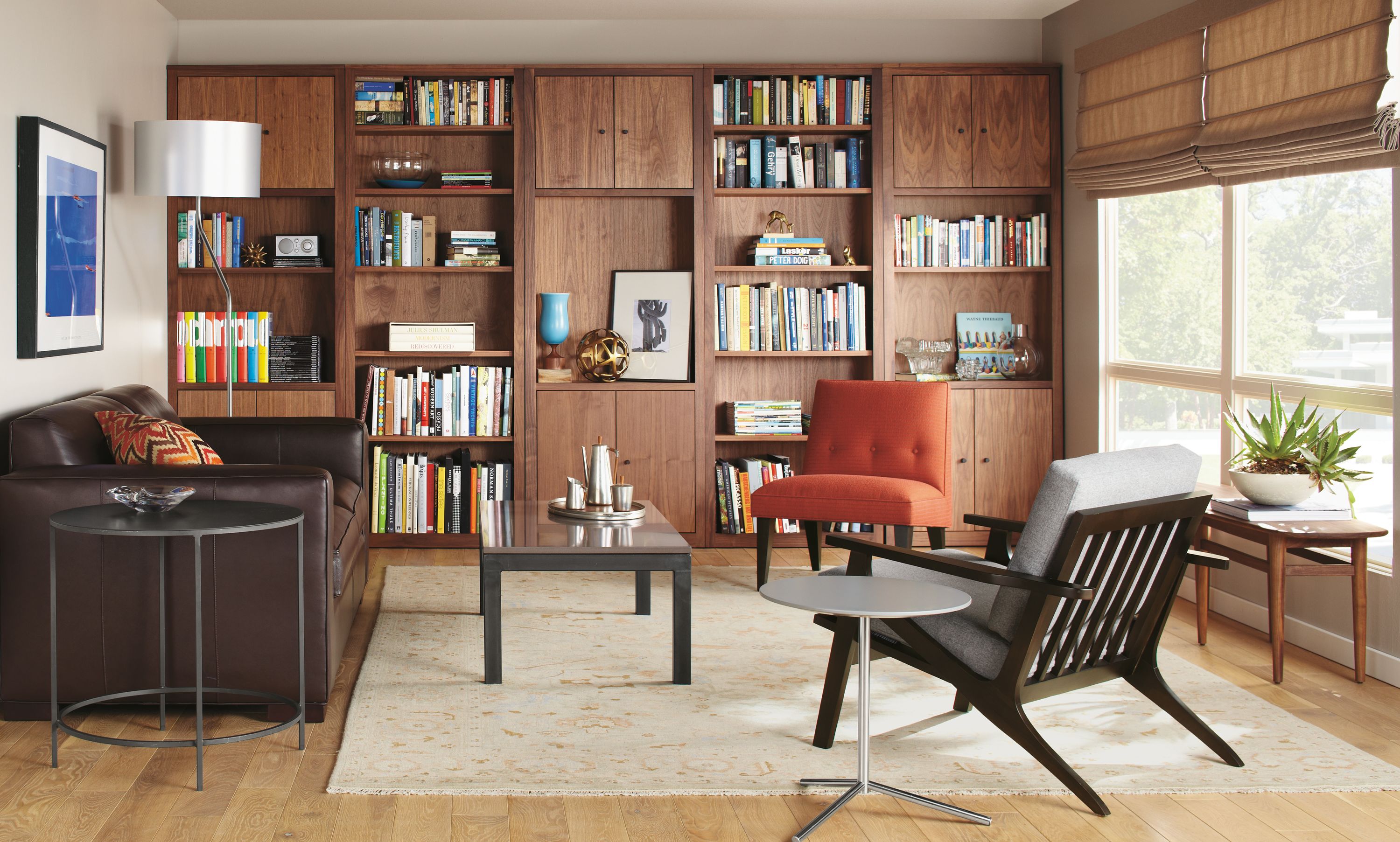 room setting including woodwind bookcases, hennepin made bowl, profile frame, ian sofa, sasha lamp.