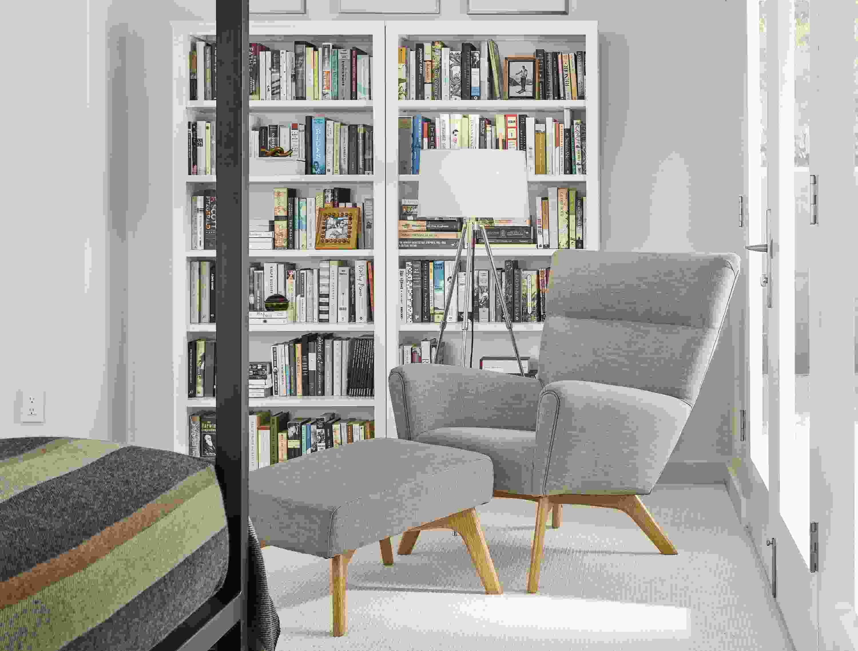 Detail of 2 Woodwind bookcases in white in small bedroom.