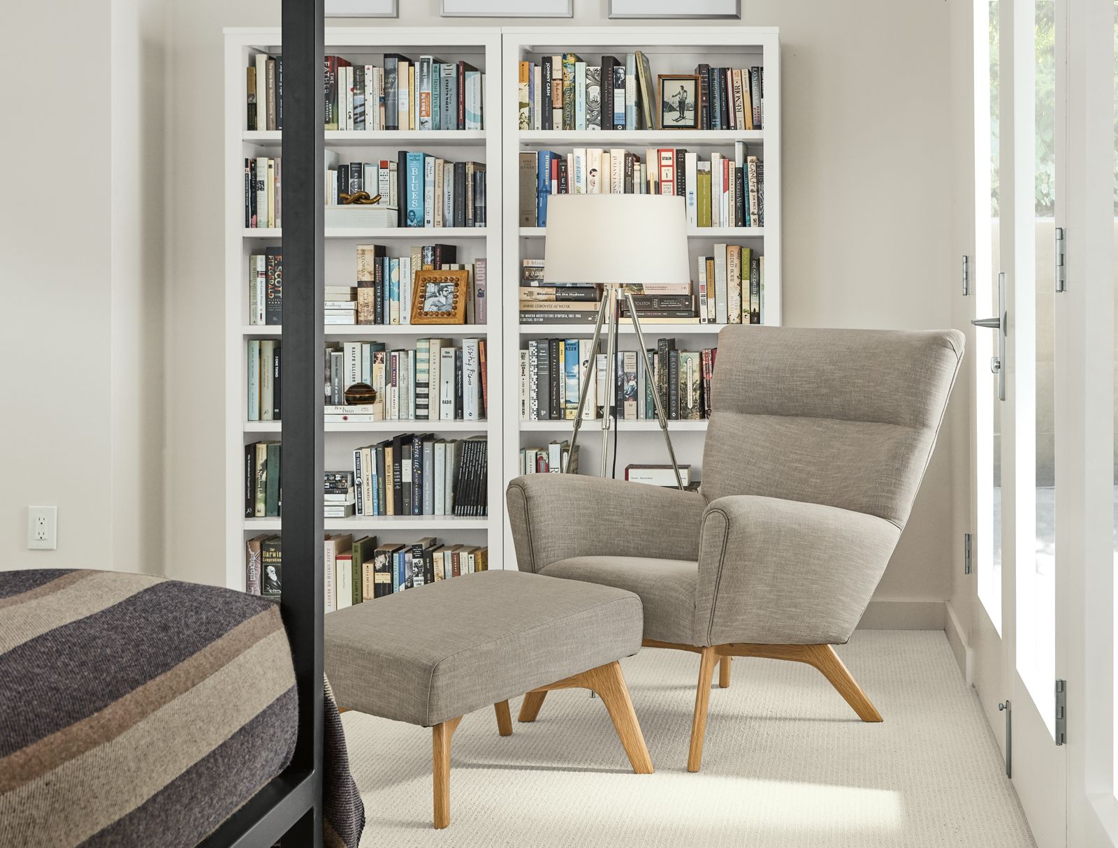 Detail of 2 Woodwind bookcases in white in small bedroom.