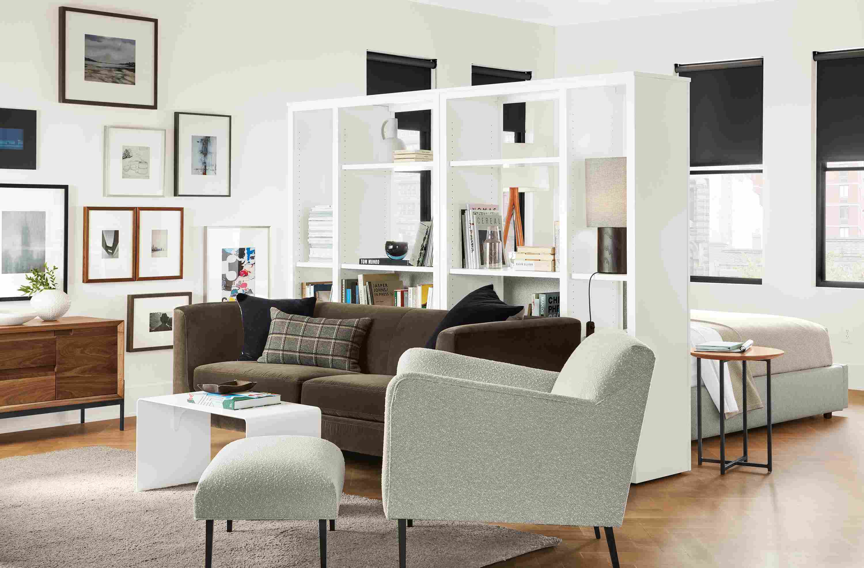 Detail of Woodwind open back bookcases in white separating sleeping and living spaces.