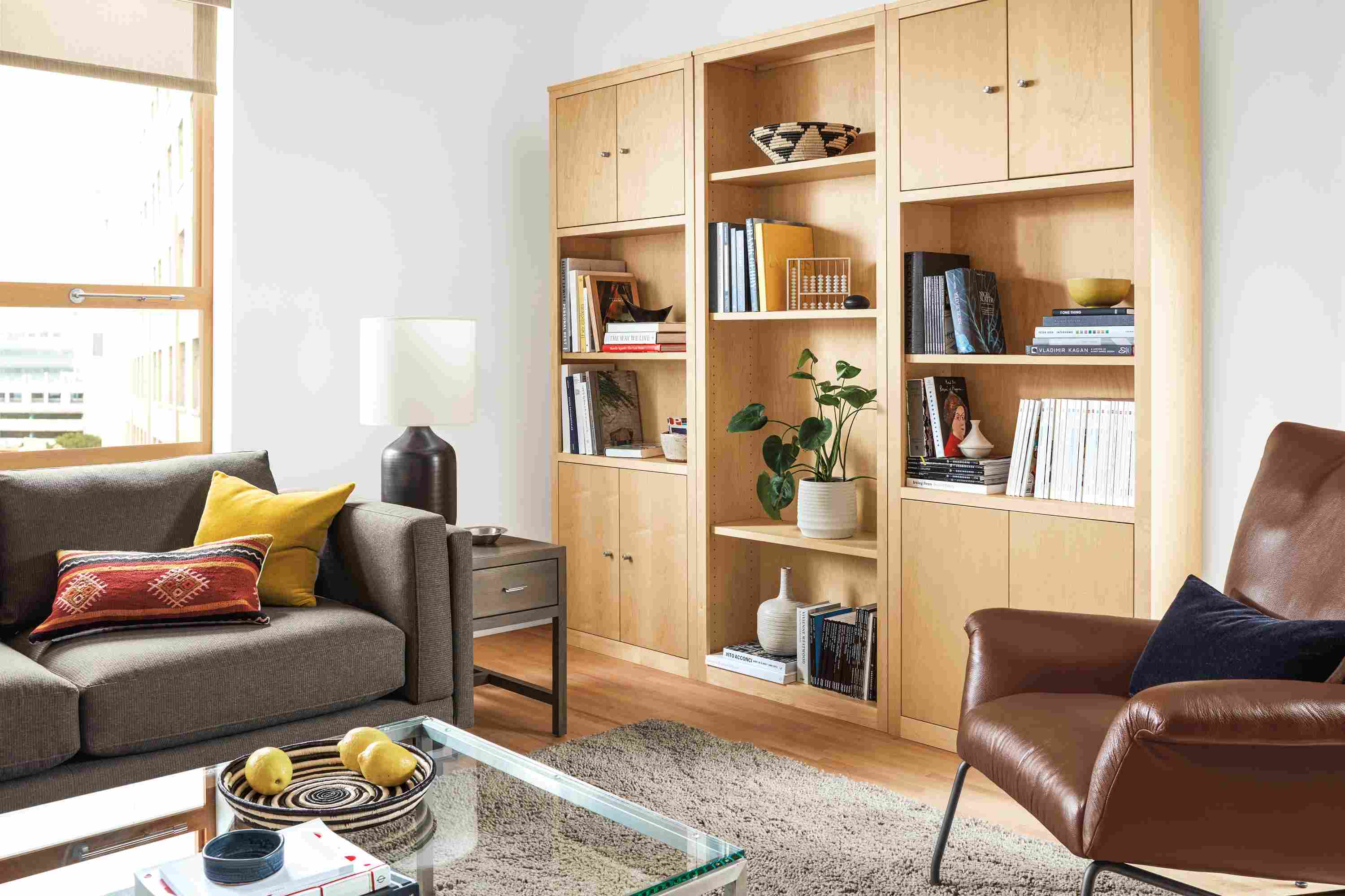 Living room with Woodwind wall unit in maple, Holden sectional in Kellen Charcoal and Arden rug in taupe.