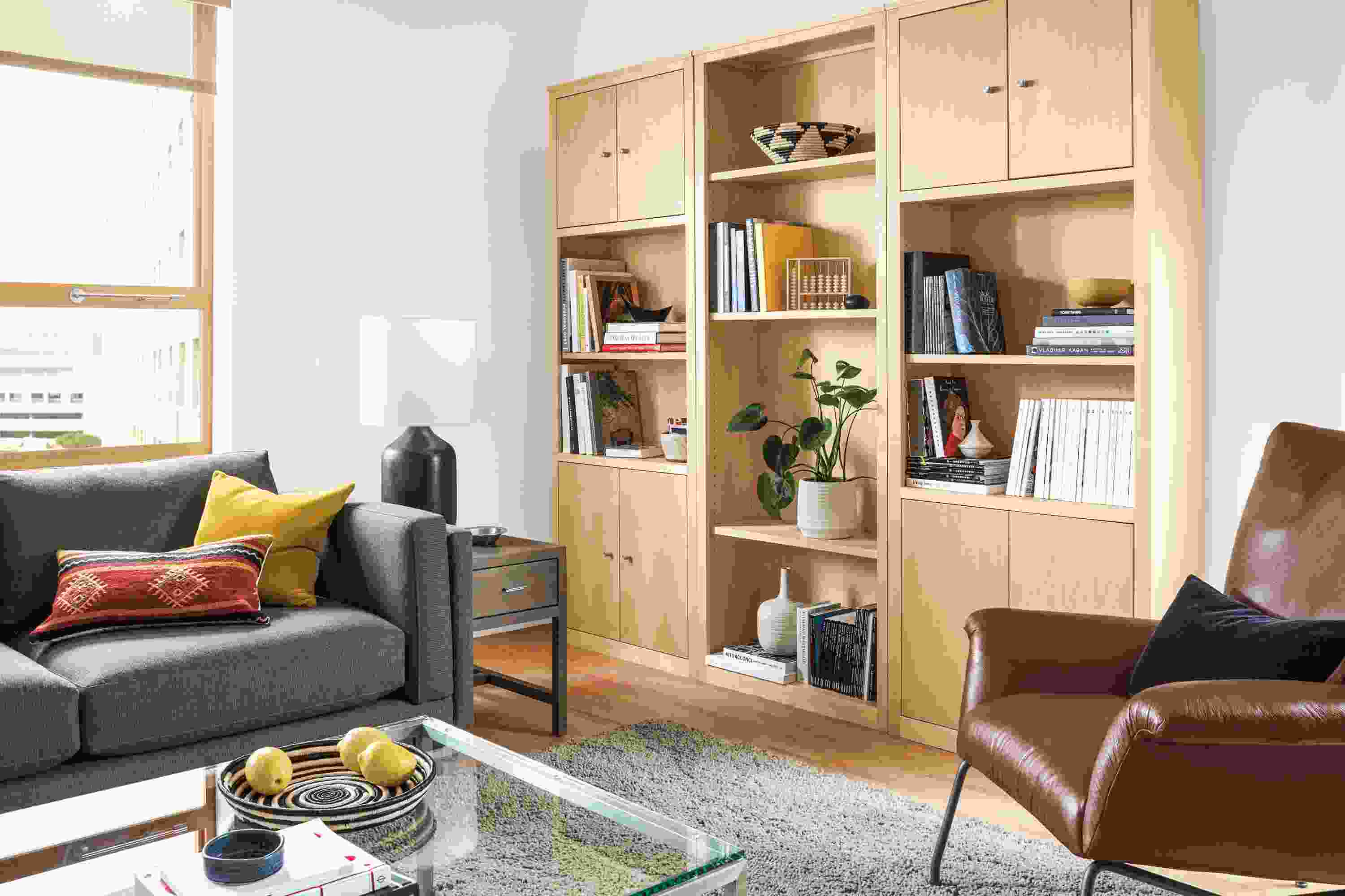 Living room with Woodwind wall unit in maple, Holden sectional in Kellen Charcoal and Arden rug in taupe.