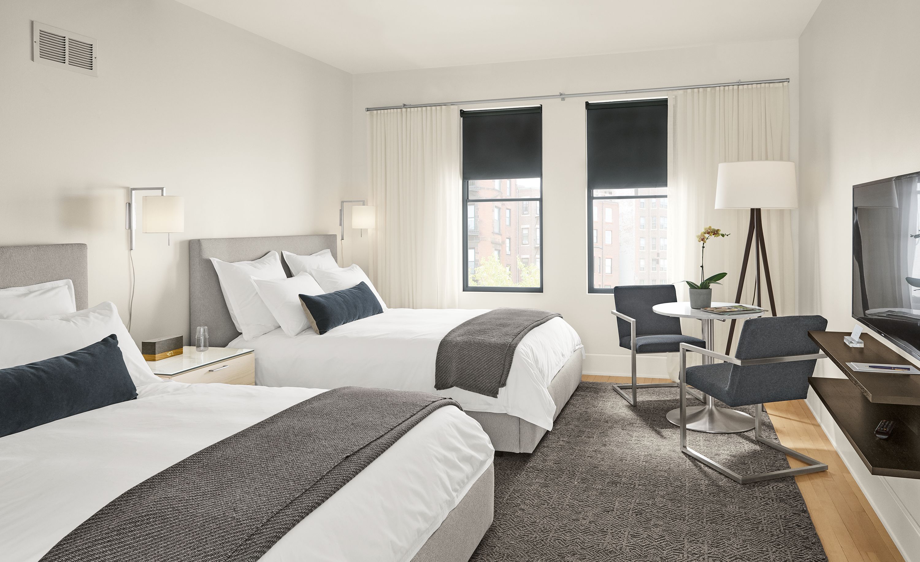 Detail of Wyatt queen beds (2) in Boyer grey fabric in hotel room.