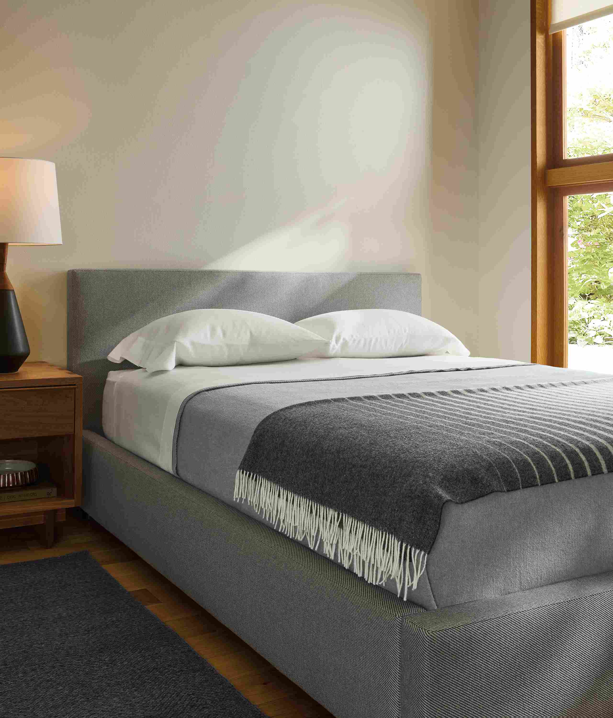 Bedroom with wyatt queen storage bed in derry cement and anton nightstand in walnut.