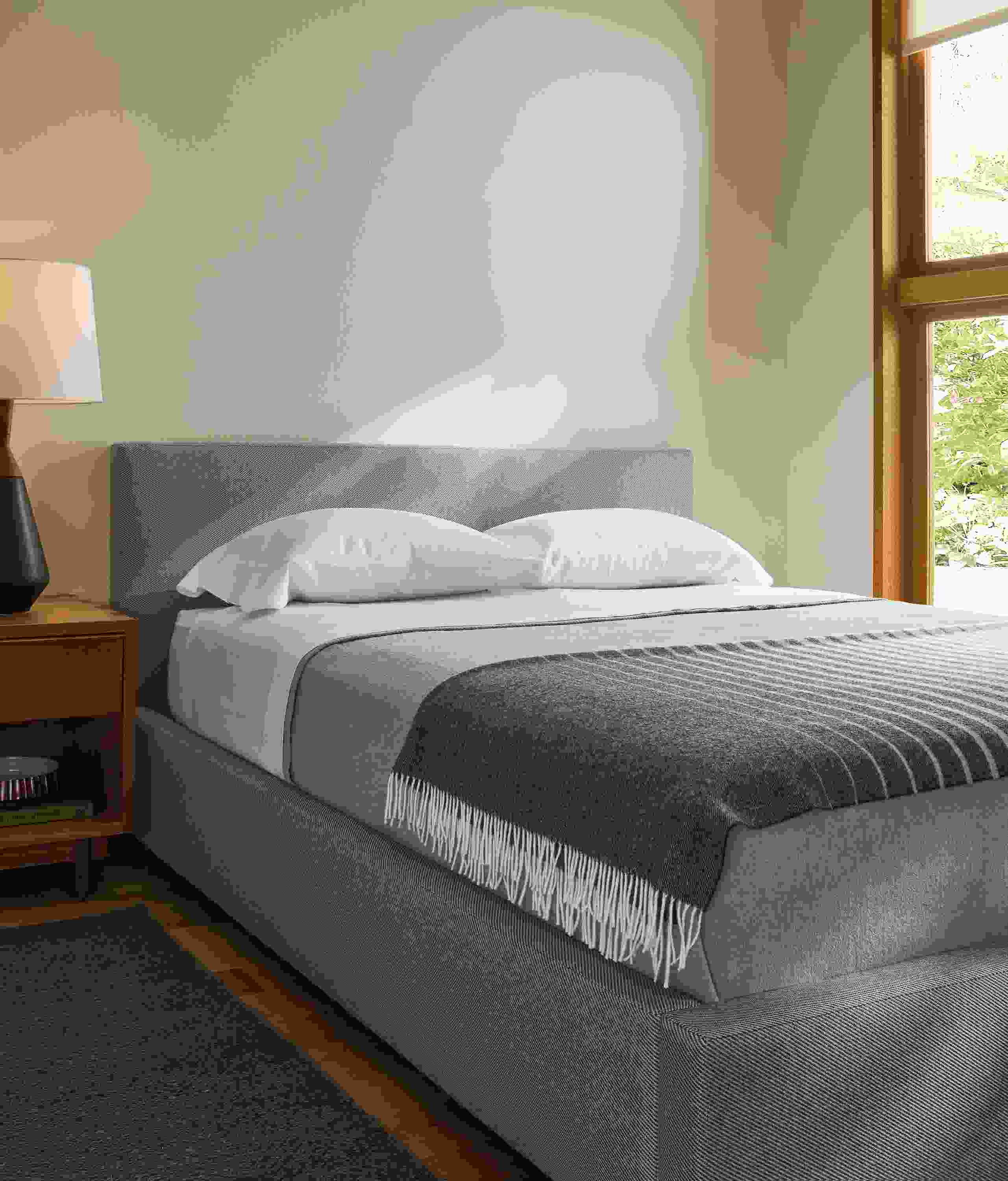 Bedroom with wyatt queen storage bed in derry cement and anton nightstand in walnut.