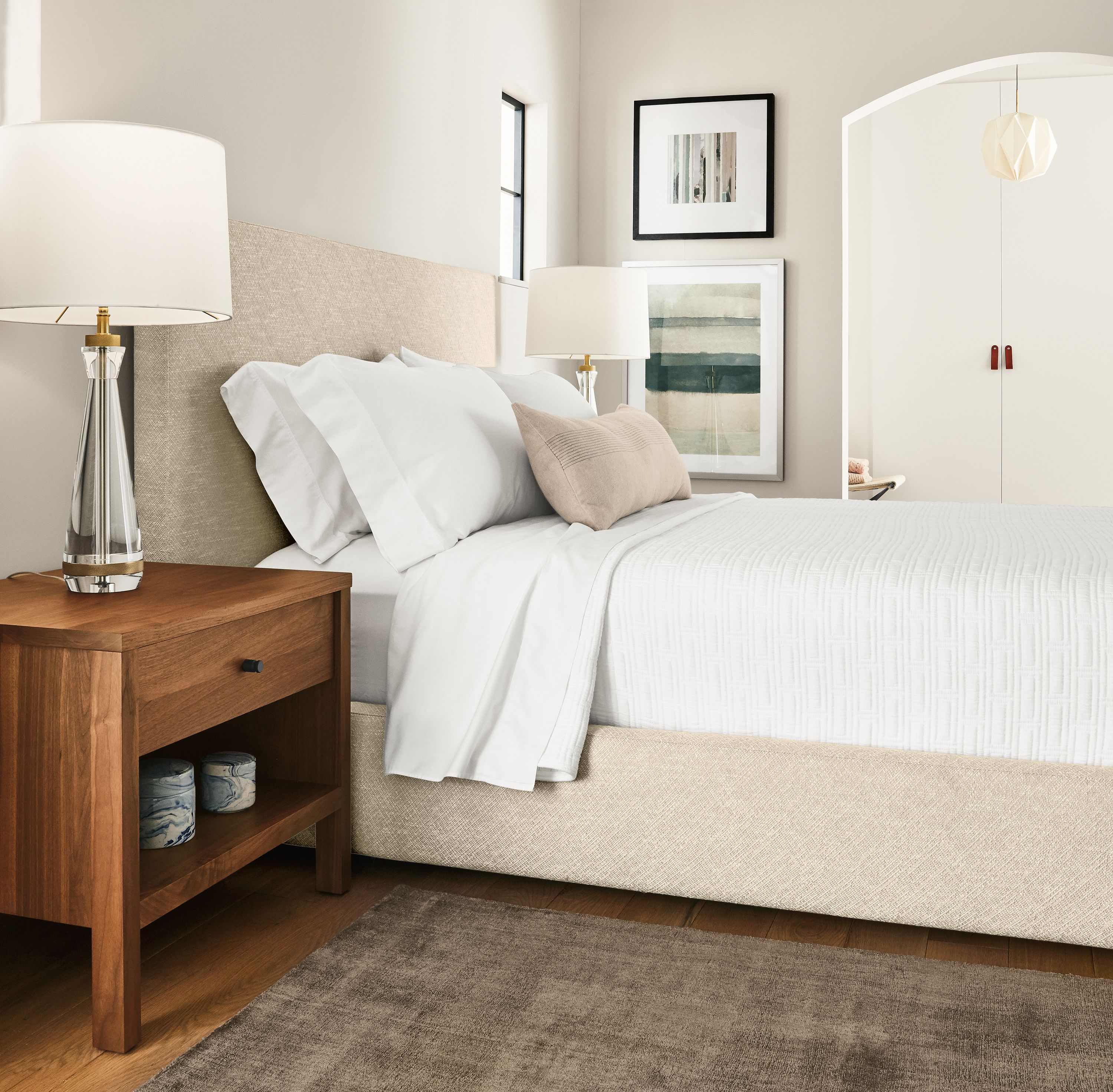 Bedroom with detail of Wyatt queen storage bed in Garett Oatmeal and Emerson nightstand in walnut.