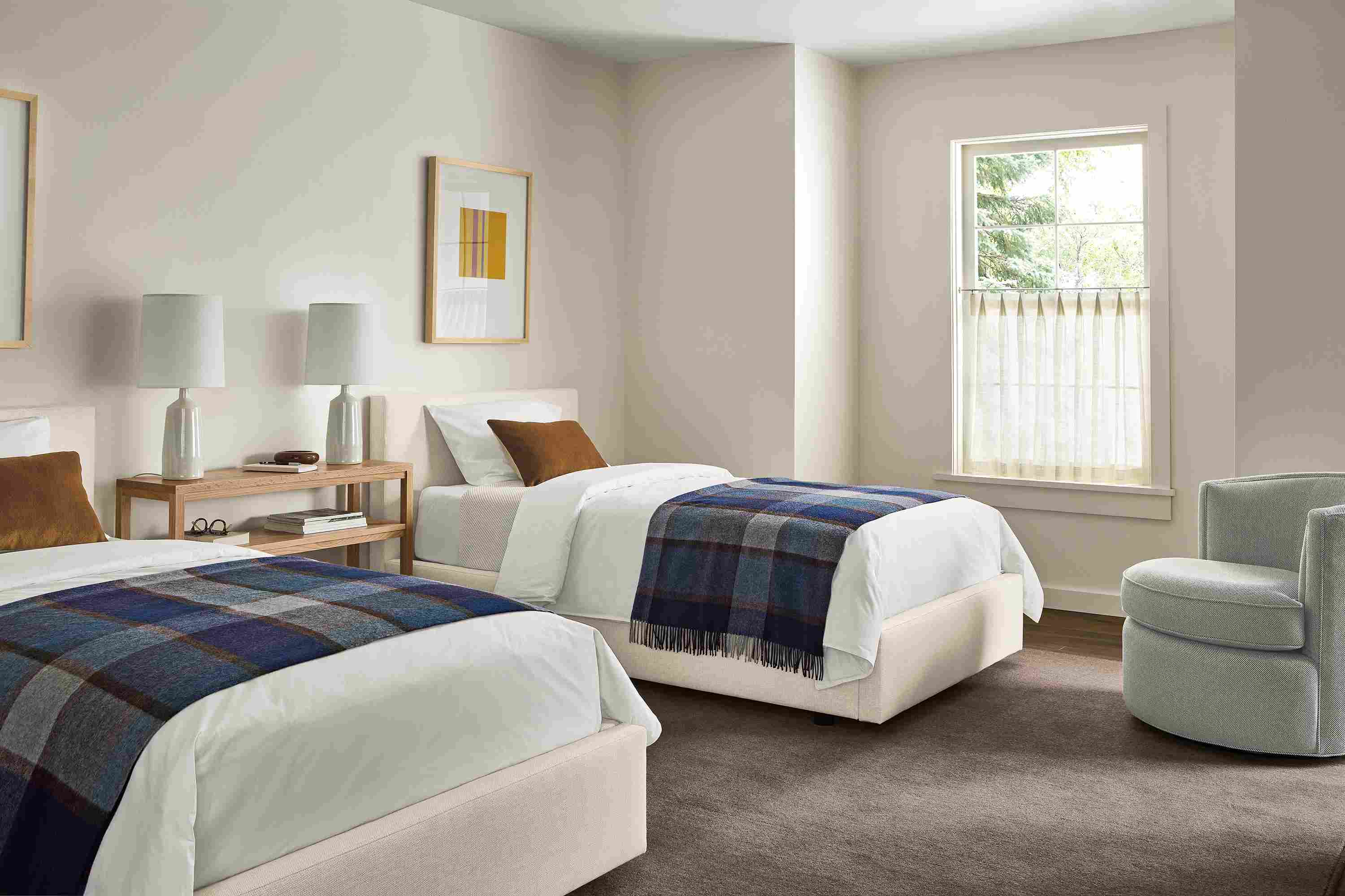 Bedroom with 2 Wyatt twin beds in Sumner Ivory and an Otis swivel chair in Derry Cement.