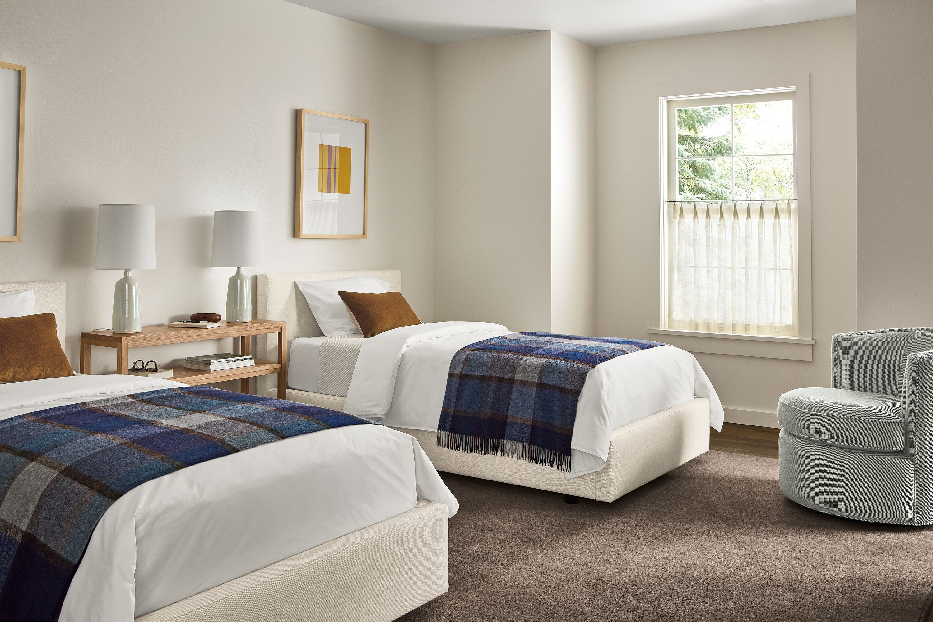 Bedroom with 2 Wyatt twin beds in Sumner Ivory and an Otis swivel chair in Derry Cement.