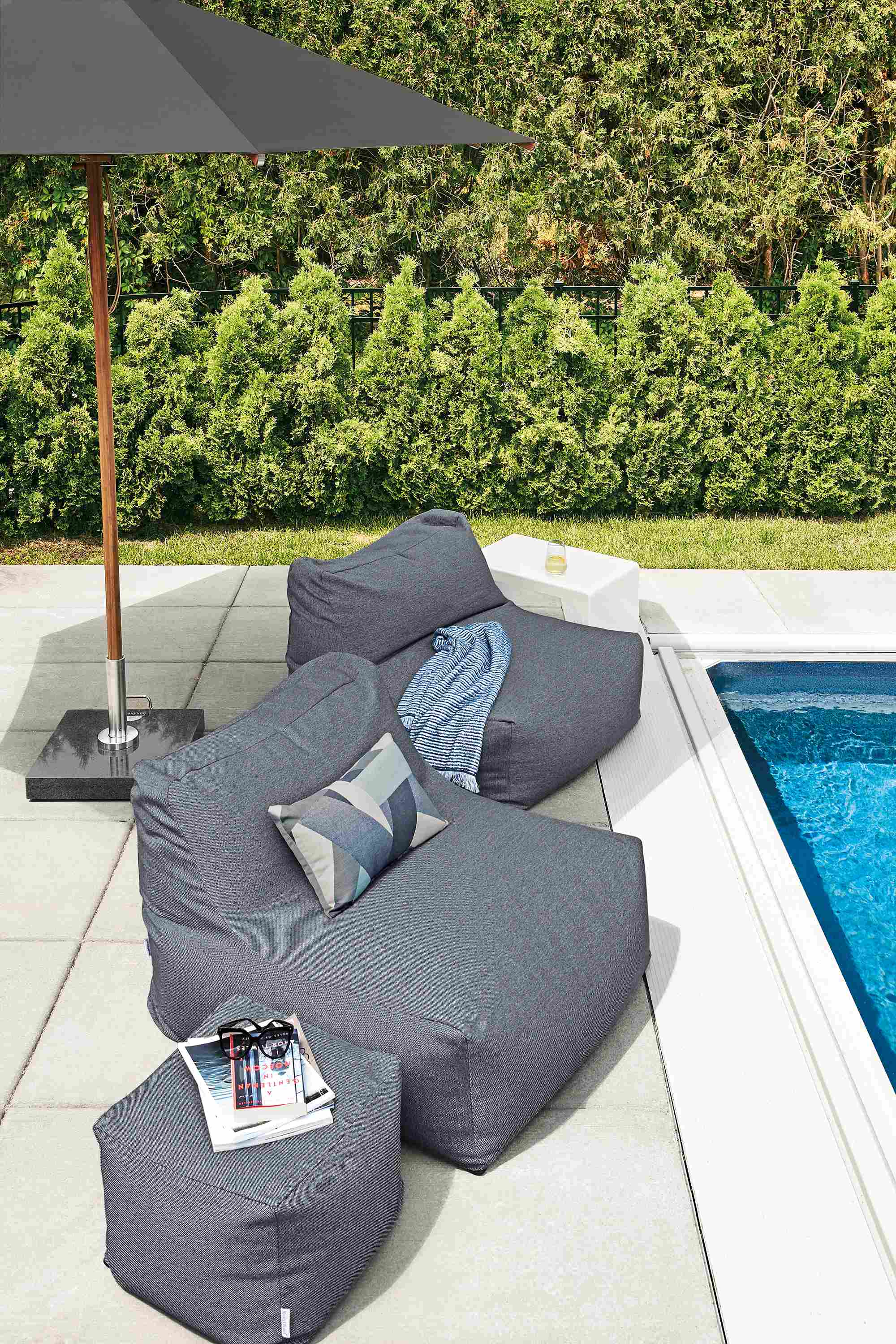 Detail of Yamba chairs alongside pool with Cirro umbrella.
