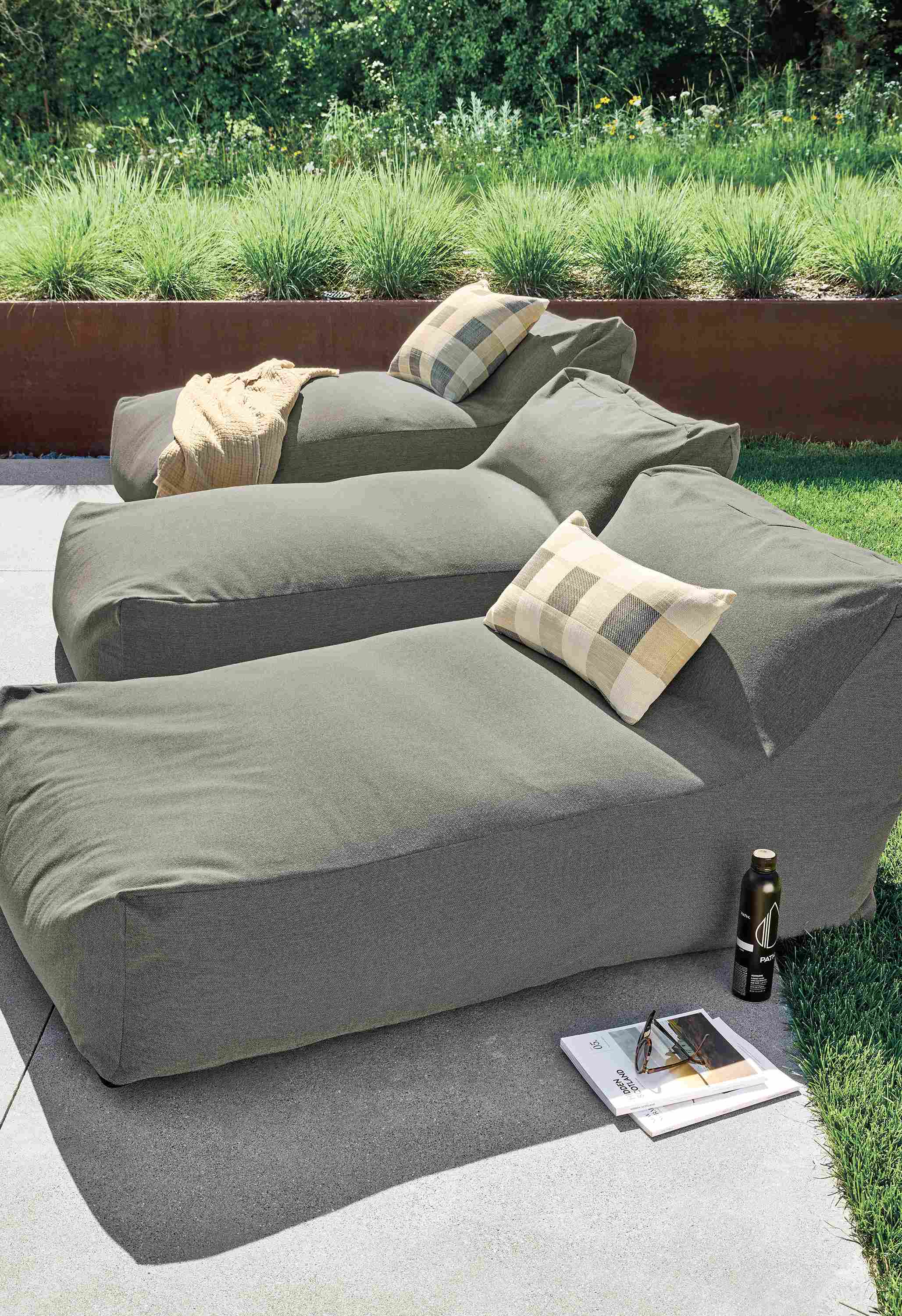 Patio with 3 Yamba chaises in pelham grey and 2 Suki outdoor pillows in earth.