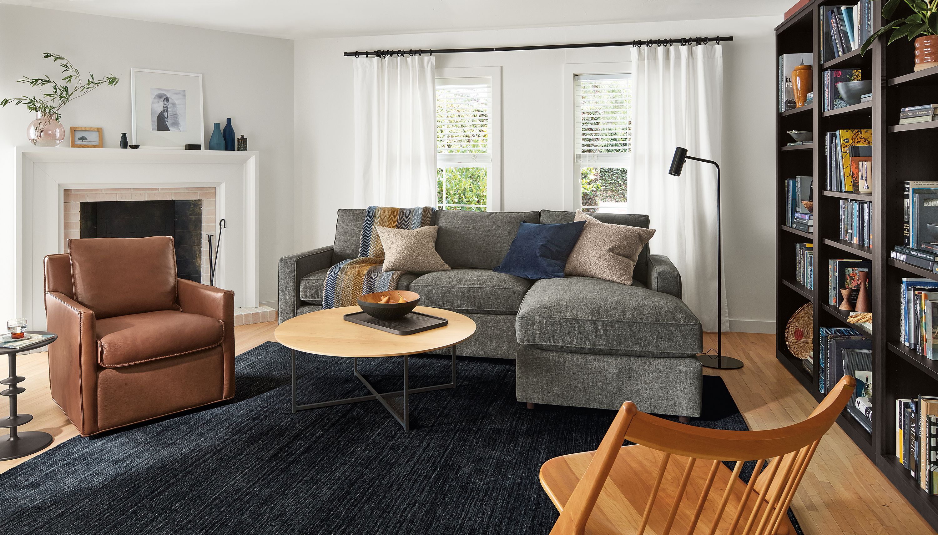 Living room with York sofa, Bram chair, Oskar chair, Classic coffee table, black rug.