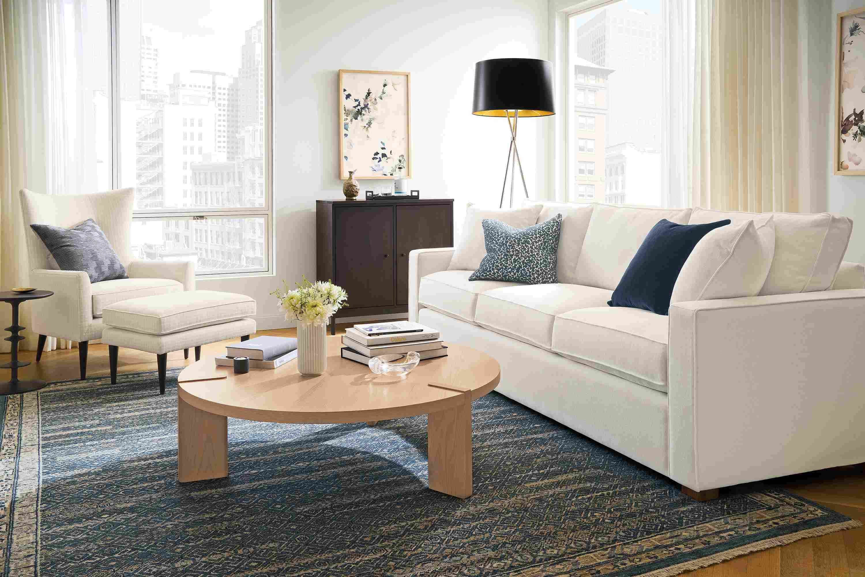 Living room with york 98-wide sofa in landen white, bradford chair and ottoman in prado natural and anza 8 by 10 rug in marine.