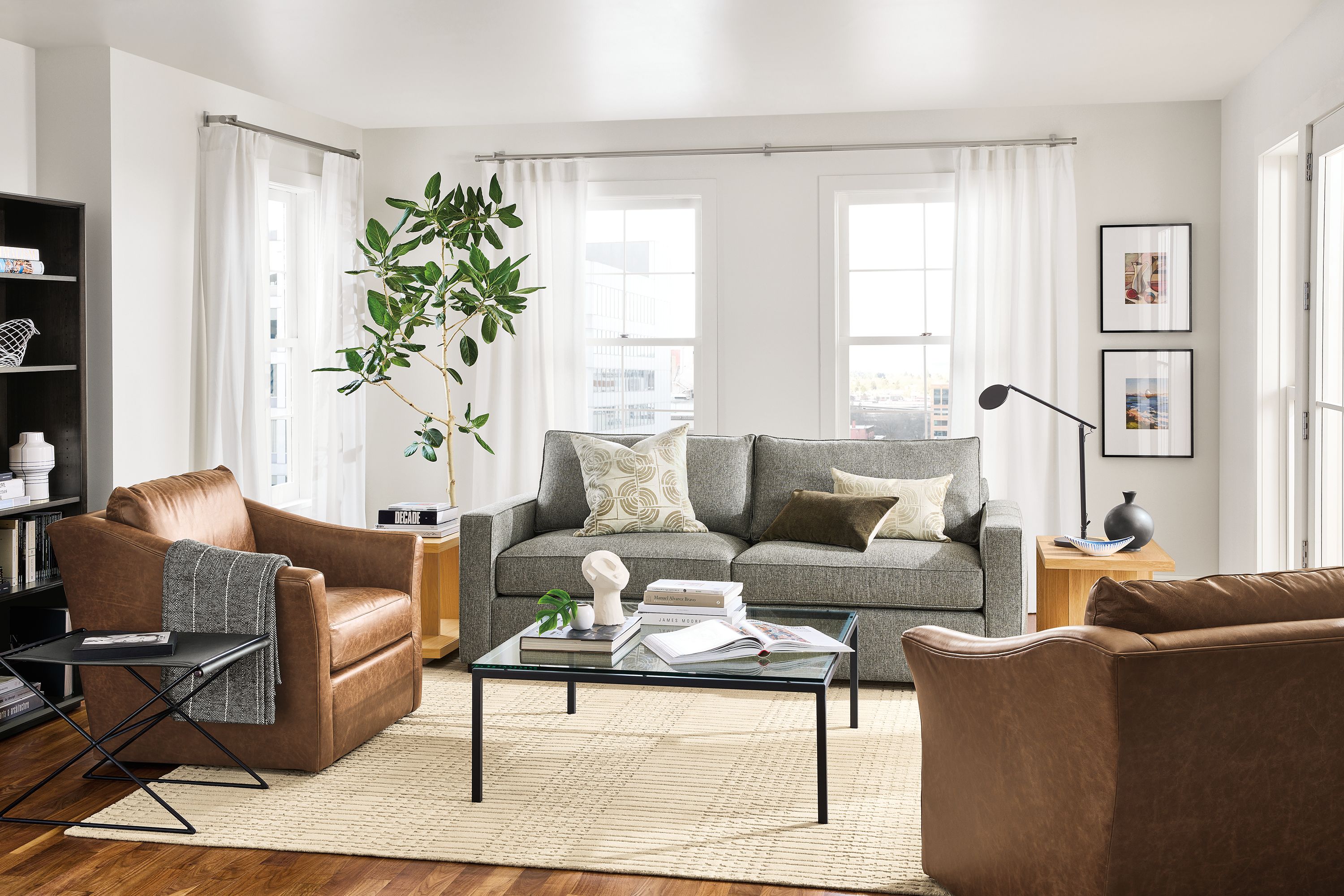 living room with york sofa in tepic grey fabric, maeve swivel chairs in leather and parsons coffee table.